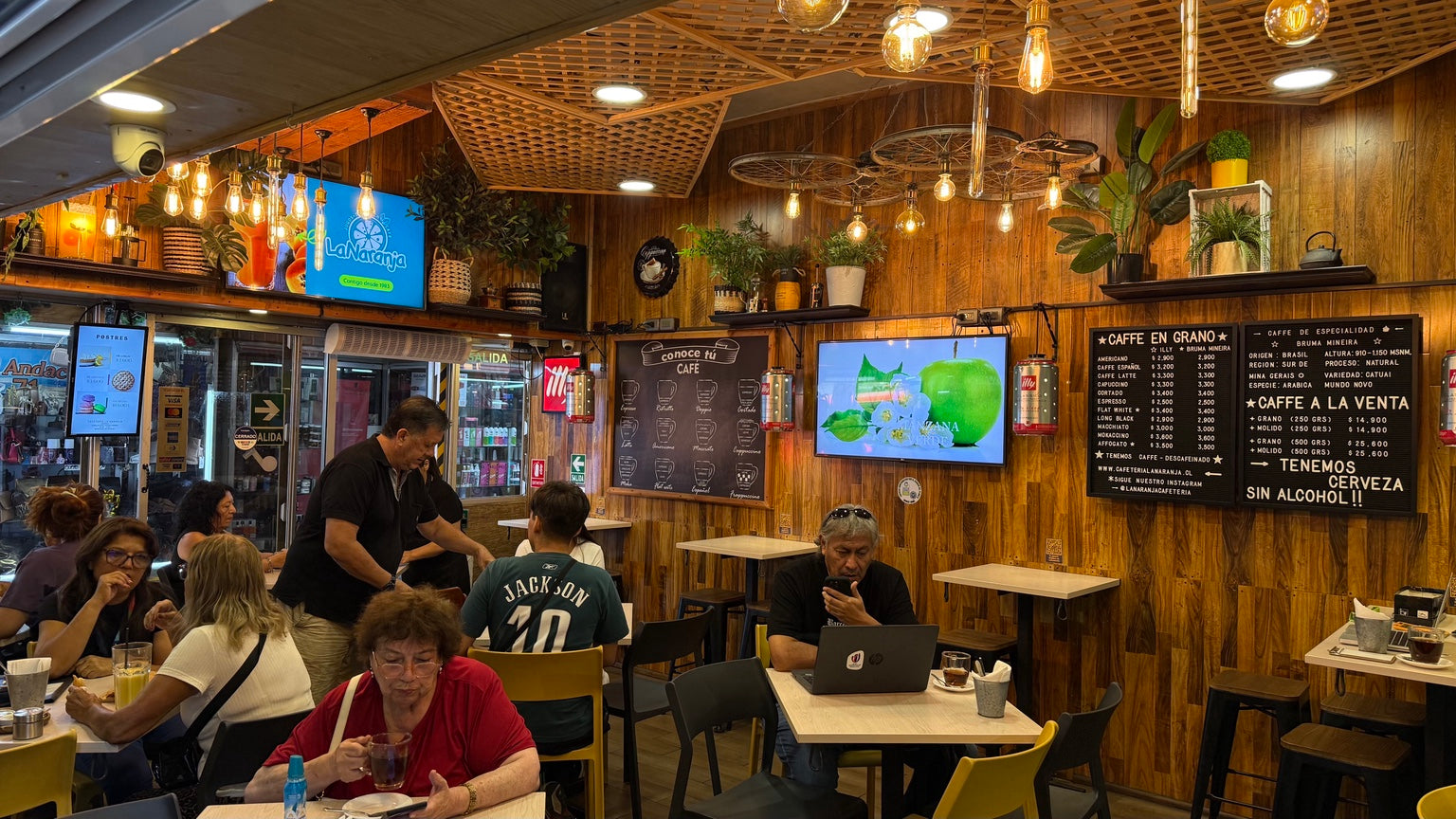 Interior de Cafetería La Naranja en Arica con clientes disfrutando café