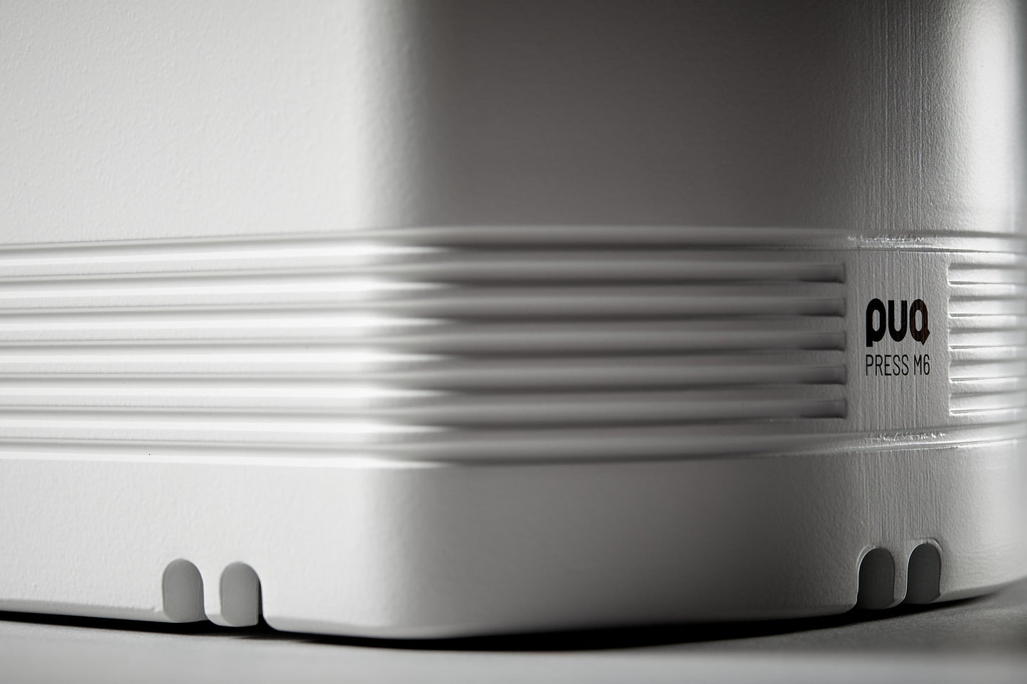 Detalle lateral con logotipo PUQ Press M6 blanco