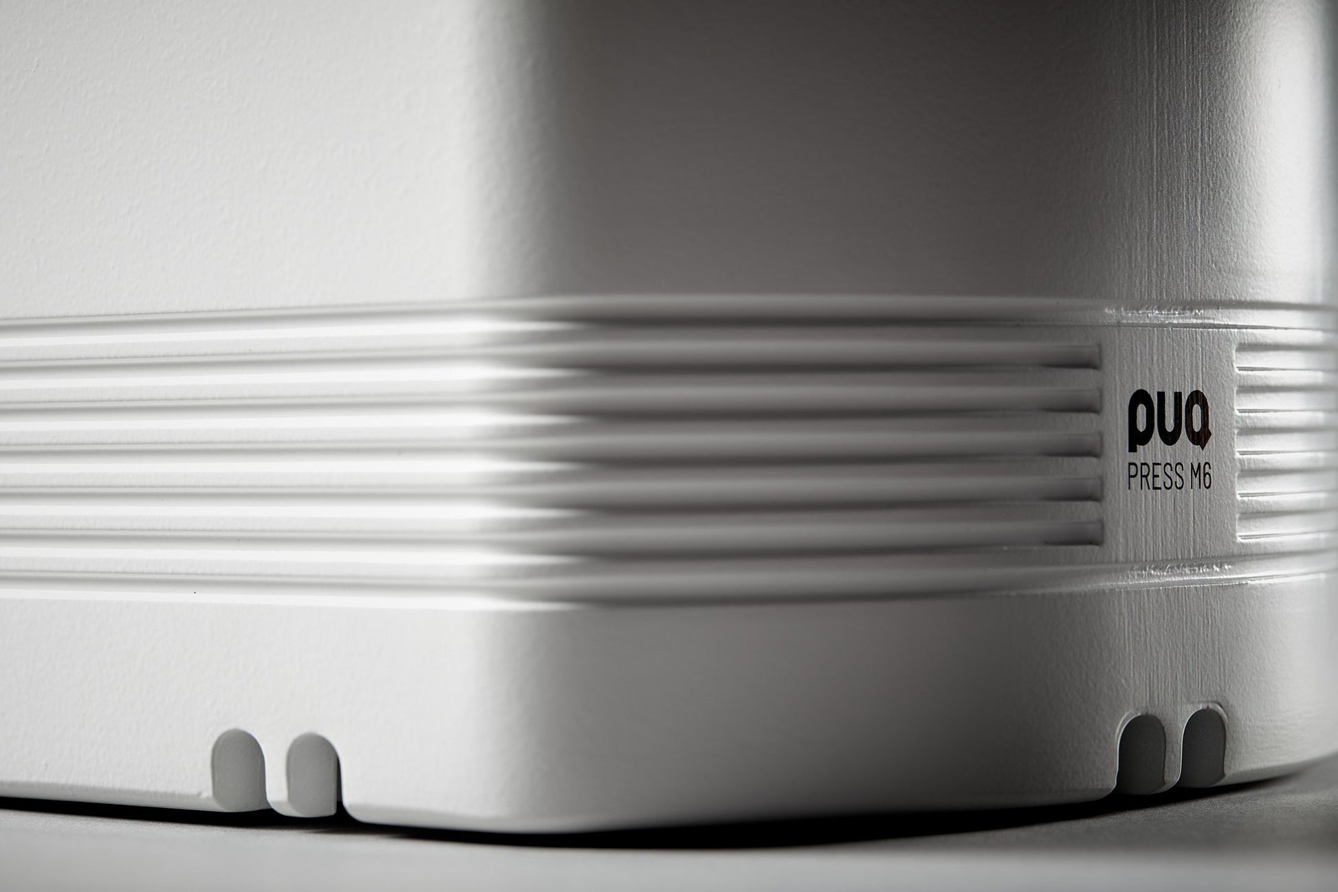 Detalle lateral con logotipo PUQ Press M6 blanco