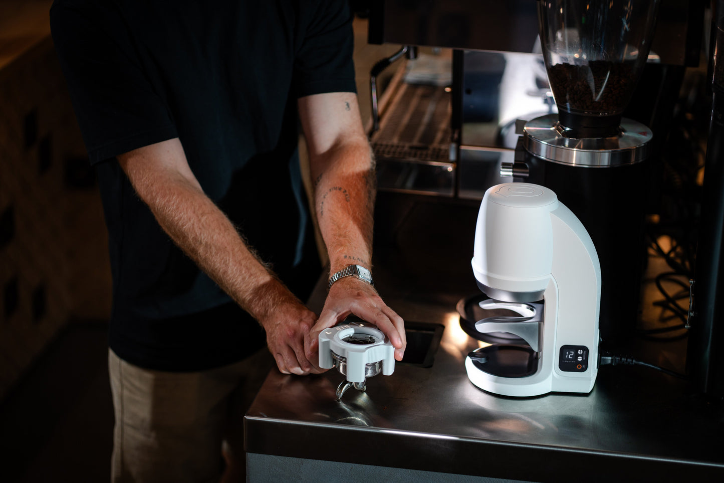 Barista preparando un portafiltro junto a PUQ Press PRO blanco