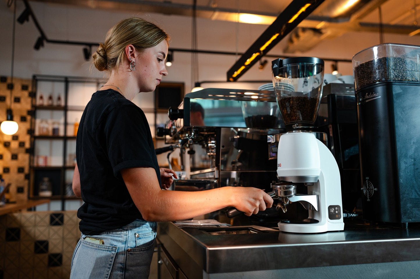 PUQ Press Q blanco junto a una máquina de espresso